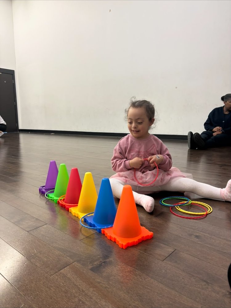 Une enfant joue avec des cônes colorés